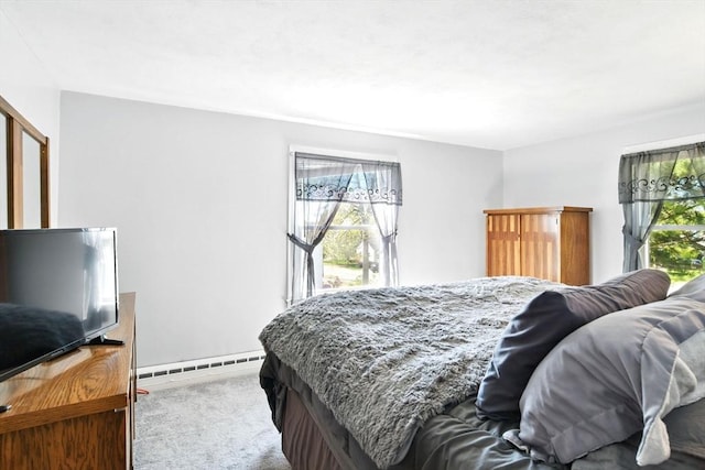 bedroom with multiple windows, baseboard heating, and carpet flooring