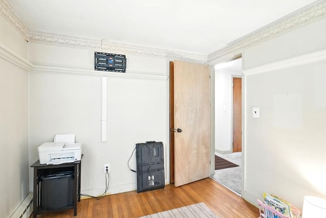 empty room with wood finished floors and baseboard heating