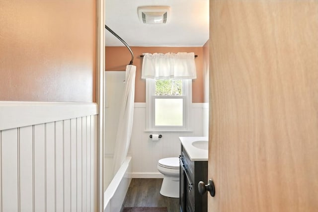 full bath featuring wainscoting, vanity, toilet, wood finished floors, and visible vents