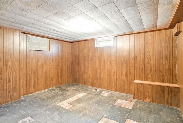 below grade area featuring wooden walls and tile patterned floors