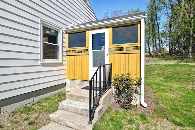 entrance to property featuring a lawn