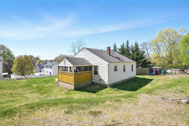 back of house with a lawn, a shingled roof, fence, and a chimney