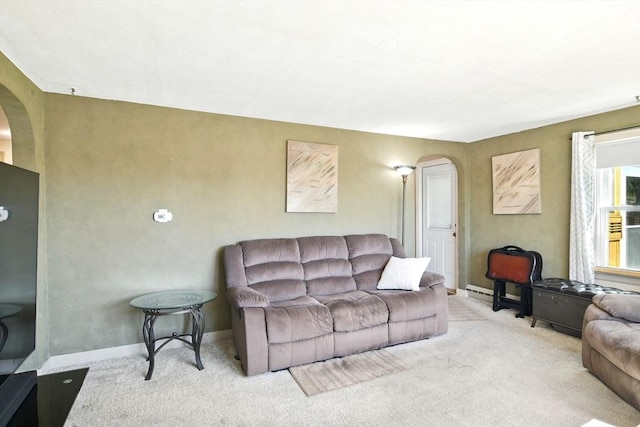 living room featuring carpet floors, arched walkways, and baseboards