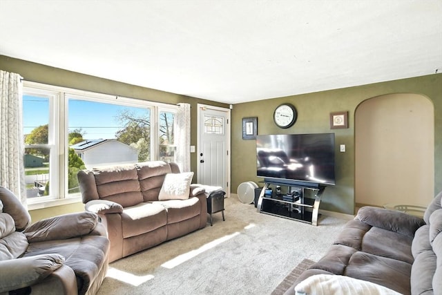 living area featuring carpet flooring and arched walkways