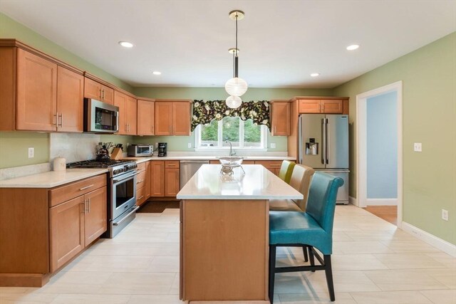 26 Crosswinds Way, Falmouth, MA 02536 - kitchen featuring a kitchen breakfast bar, light countertops, stainless steel appliances, a kitchen island, and a sink
