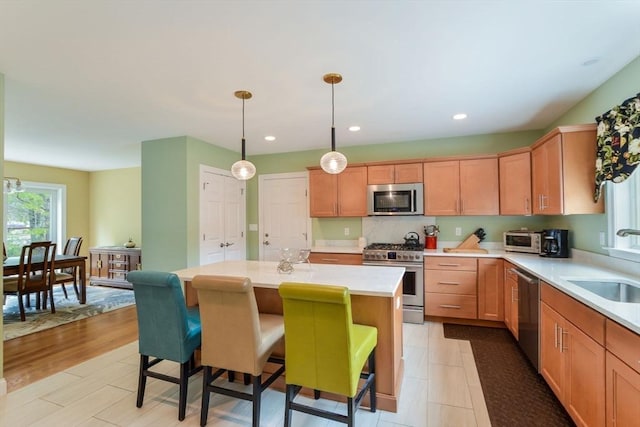 26 Crosswinds Way, Falmouth, MA 02536 - kitchen featuring light countertops, a kitchen island, appliances with stainless steel finishes, a sink, and a breakfast bar area