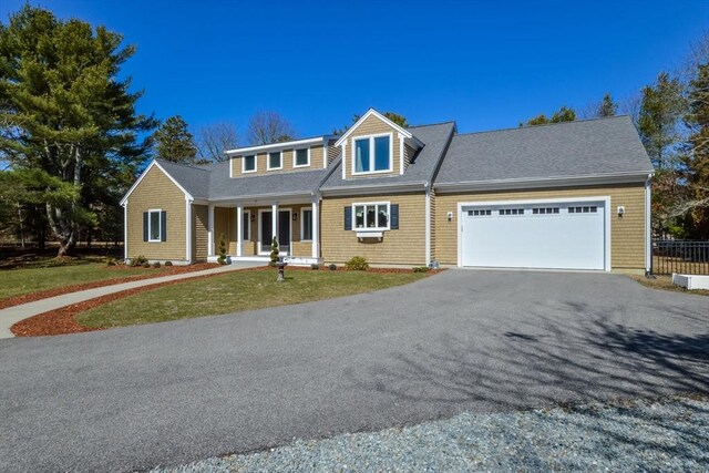 26 Crosswinds Way, Falmouth, MA 02536 - view of front of house with driveway, covered porch, fence, an attached garage, and a front lawn