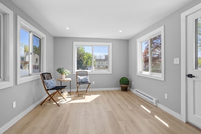 living area featuring wood finished floors, recessed lighting, baseboards, and a baseboard heating unit