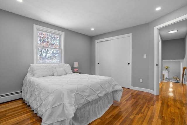 bedroom with recessed lighting, baseboards, wood finished floors, and a closet