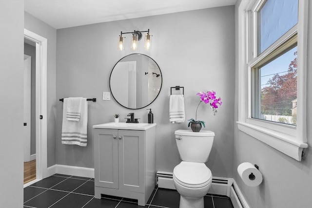 bathroom featuring tile patterned flooring, vanity, toilet, baseboards, and a baseboard heating unit