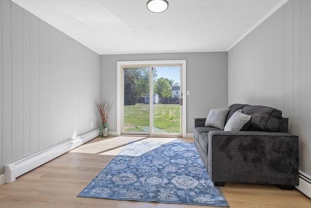 living area featuring a baseboard radiator, ornamental molding, and wood finished floors