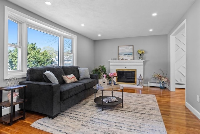 living area with recessed lighting, wood finished floors, and a wealth of natural light