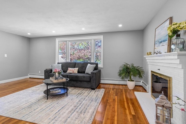 living area with baseboards, recessed lighting, wood finished floors, and baseboard heating