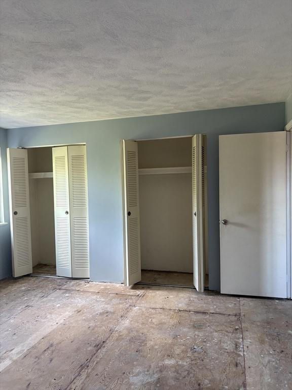 740 Central St Unit J11, Leominster, MA 01453 - unfurnished bedroom featuring multiple closets and a textured ceiling
