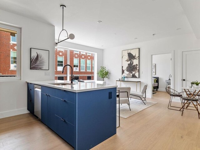 27 Dixwell Unit 8, Boston, MA 02119 - kitchen with blue cabinetry, a sink, light wood-type flooring, light countertops, and stainless steel dishwasher