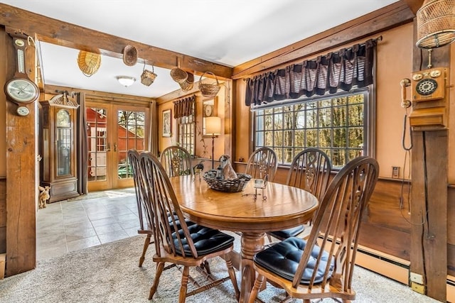 tiled dining room featuring beamed ceiling and french doors