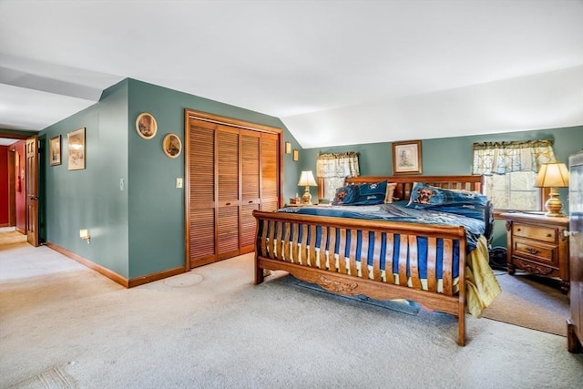 bedroom with carpet floors, baseboards, vaulted ceiling, and a closet