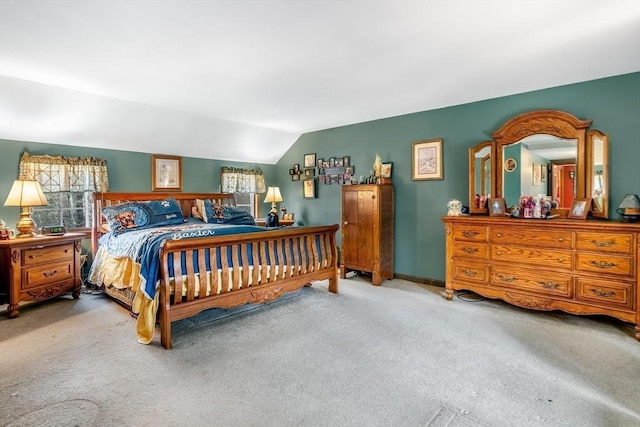 carpeted bedroom featuring baseboards and lofted ceiling