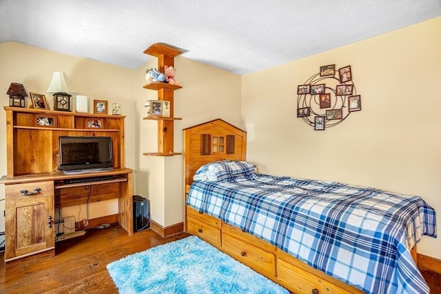 bedroom with wood-type flooring, a textured ceiling, baseboards, and lofted ceiling