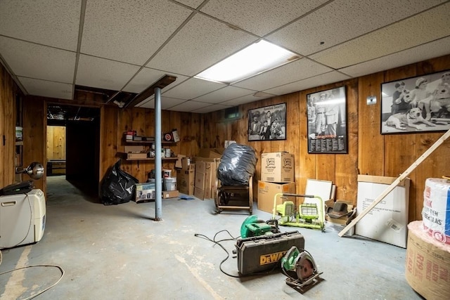 finished basement with wood walls and a drop ceiling