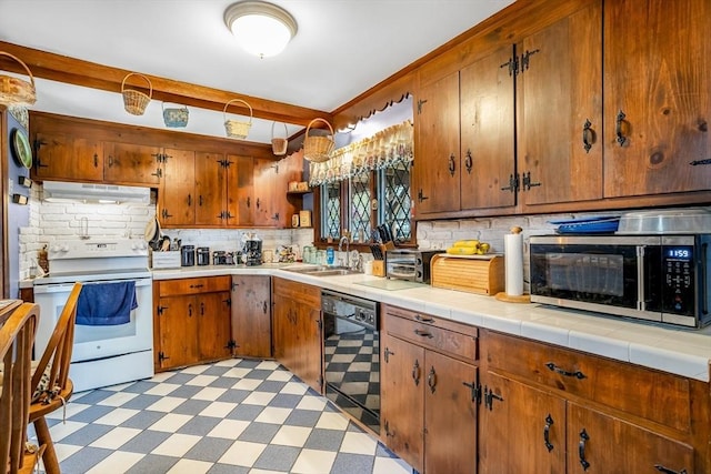 kitchen with electric range, a sink, black dishwasher, stainless steel microwave, and light floors
