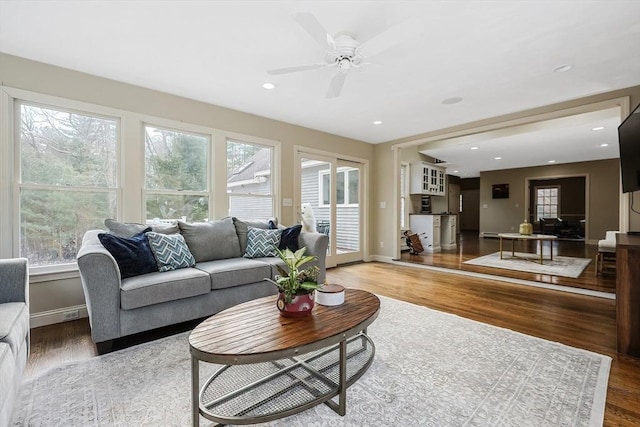 living room featuring wood-type flooring and ceiling fan