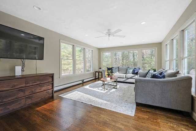 living room with dark hardwood / wood-style flooring, ceiling fan, and baseboard heating