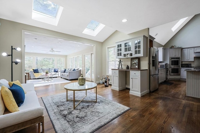 living room featuring dark wood-type flooring and vaulted ceiling with skylight