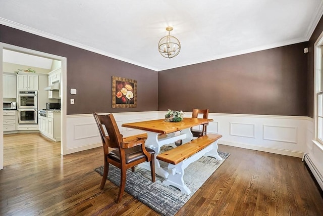 dining space featuring crown molding, a baseboard radiator, wood-type flooring, and a chandelier