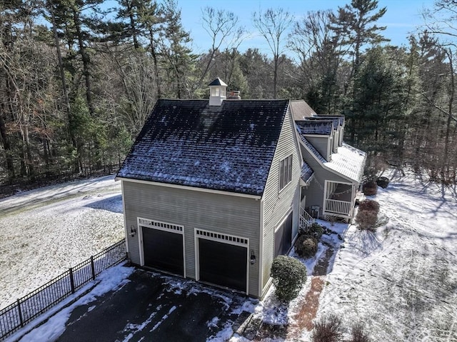 view of snowy exterior featuring a garage