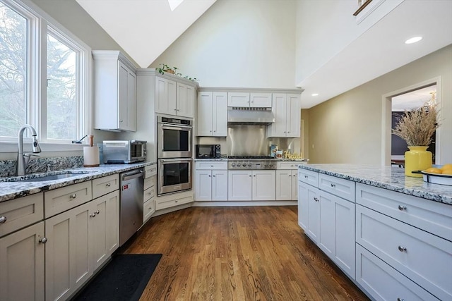 kitchen with light stone counters, sink, white cabinets, and appliances with stainless steel finishes