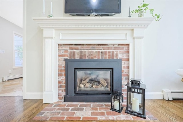 room details with hardwood / wood-style flooring, a fireplace, and a baseboard radiator