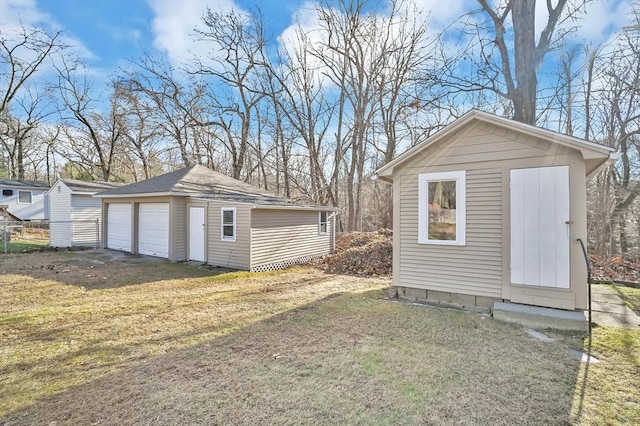 view of outbuilding featuring a lawn and a garage