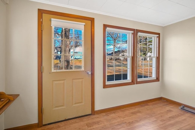 doorway to outside with crown molding and light hardwood / wood-style flooring