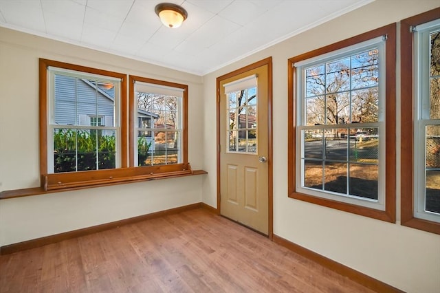 doorway featuring wood-type flooring and ornamental molding