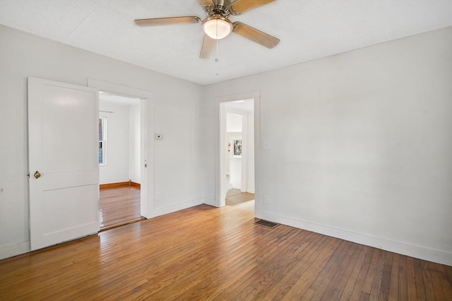 spare room with a wealth of natural light, light hardwood / wood-style flooring, and ceiling fan