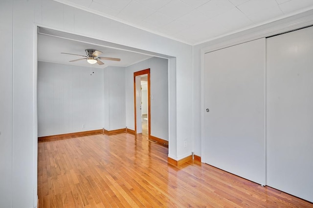 unfurnished bedroom featuring ceiling fan, light hardwood / wood-style floors, and a closet