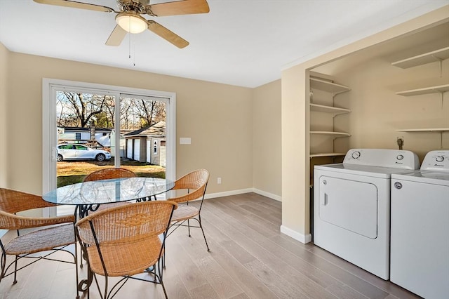 clothes washing area with ceiling fan, independent washer and dryer, and light hardwood / wood-style flooring