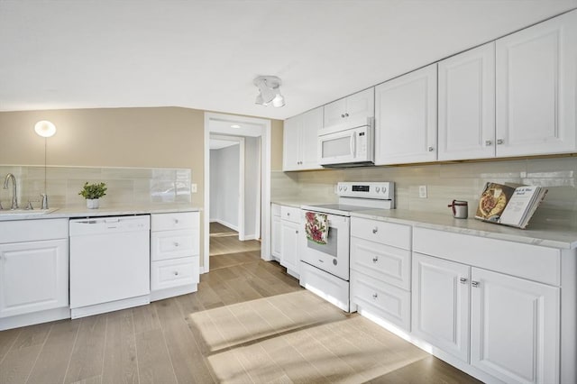 kitchen with light wood-type flooring, decorative backsplash, white appliances, and white cabinetry