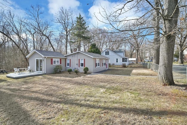 exterior space featuring a front lawn and a wooden deck