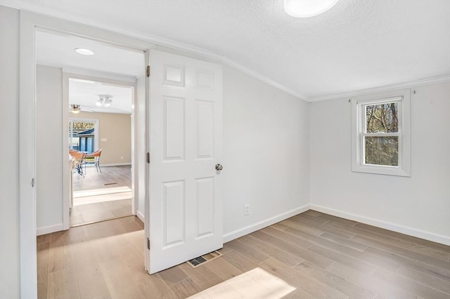 additional living space with a textured ceiling, light wood-type flooring, and ceiling fan