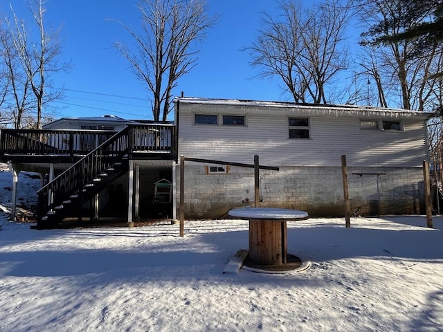 snow covered property with a wooden deck