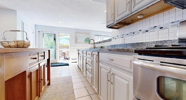32 Nelson Ave, Beverly, MA 01915 - kitchen featuring light tile patterned floors, dark countertops, white cabinetry, backsplash, and recessed lighting
