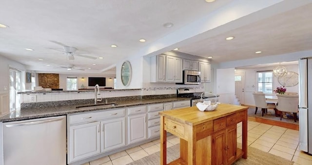32 Nelson Ave, Beverly, MA 01915 - kitchen with a wealth of natural light, stainless steel appliances, light tile patterned flooring, and a sink