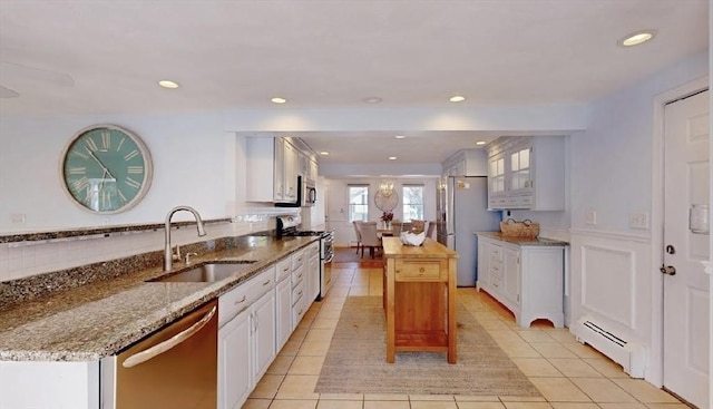 32 Nelson Ave, Beverly, MA 01915 - kitchen featuring a baseboard heating unit, light tile patterned flooring, a sink, white cabinetry, and stainless steel appliances