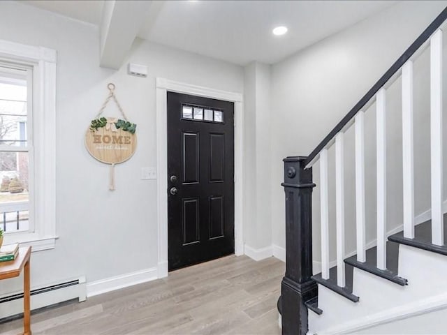 foyer featuring recessed lighting, a baseboard heating unit, baseboards, stairway, and light wood finished floors