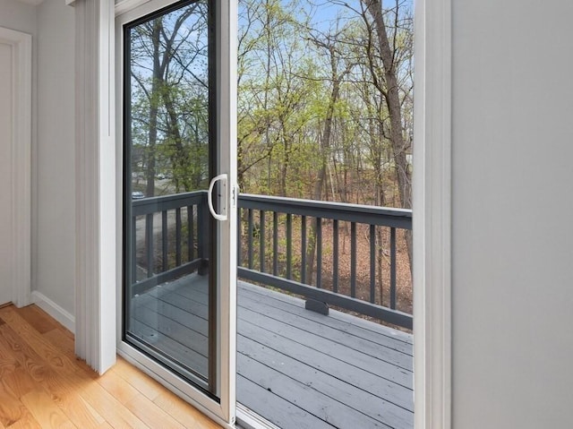 doorway to outside with baseboards and light wood-style floors