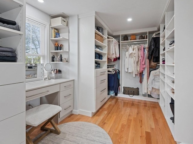 walk in closet with light wood finished floors