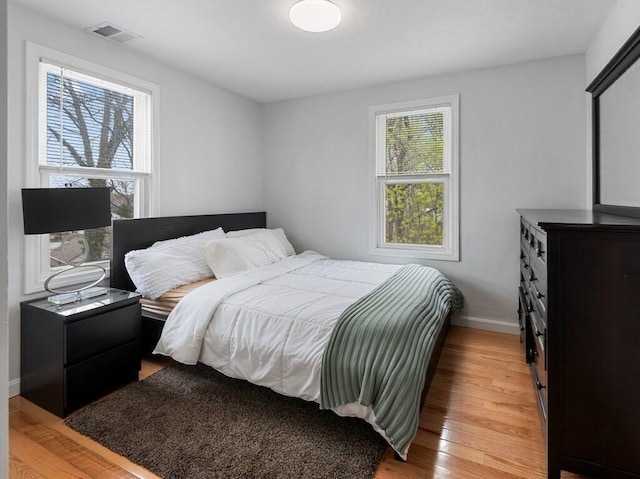 bedroom with baseboards, visible vents, and light wood-style flooring