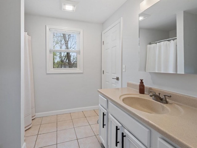 bathroom with baseboards, tile patterned floors, and vanity